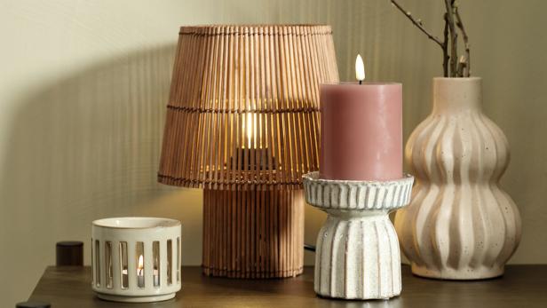 teelichthalter und eine rosa Kerze vor einer Holzlampe