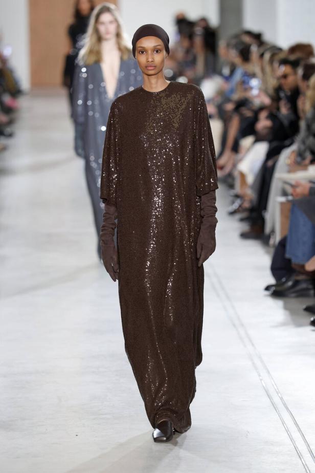 Eine Frau auf dem Laufsteg mit einem braunen Ganzkörperanzug