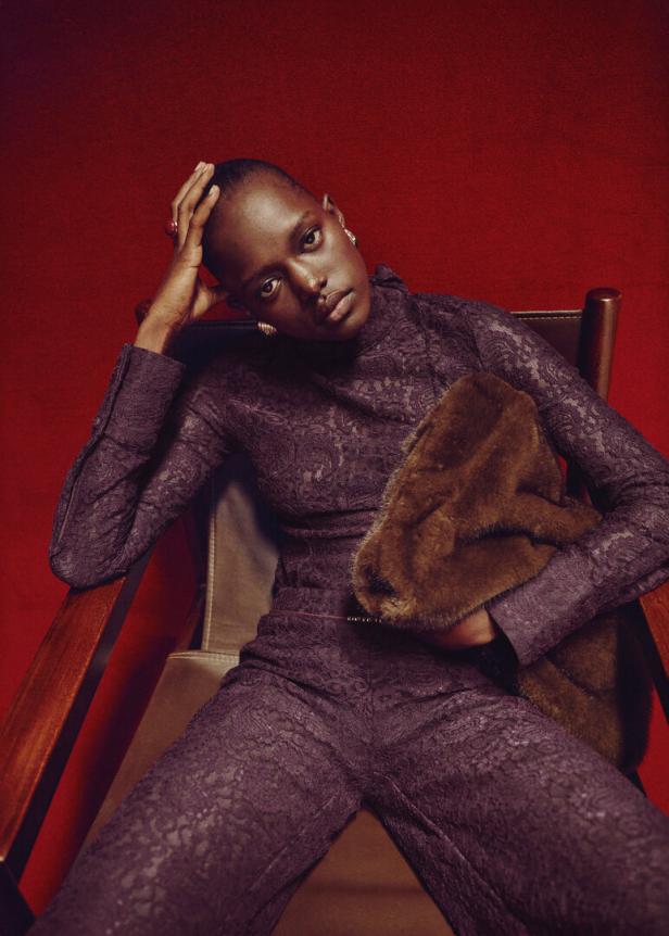 Eine Frau in einem weinroten Spitzenanzug