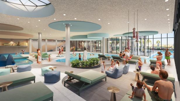 Viele Menschen entspannen und spielen in einem modernen, hellen Hallenbad mit mehreren Pools und Liegeflächen.