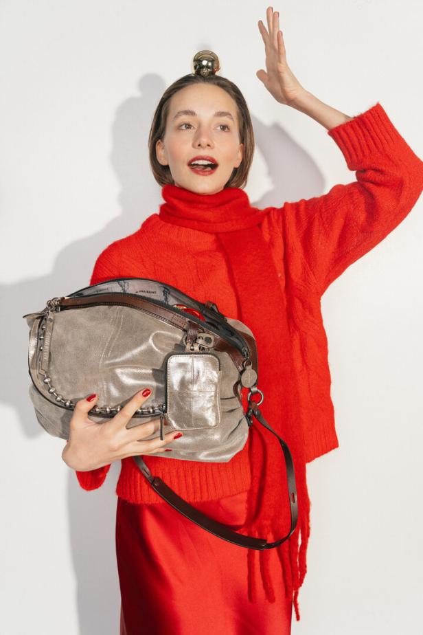 Eine Frau in einem roten Kleid mit einer goldenen Tasche