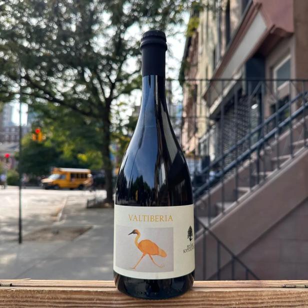 eine schwarze Sektflasche mit weißem Etikett 