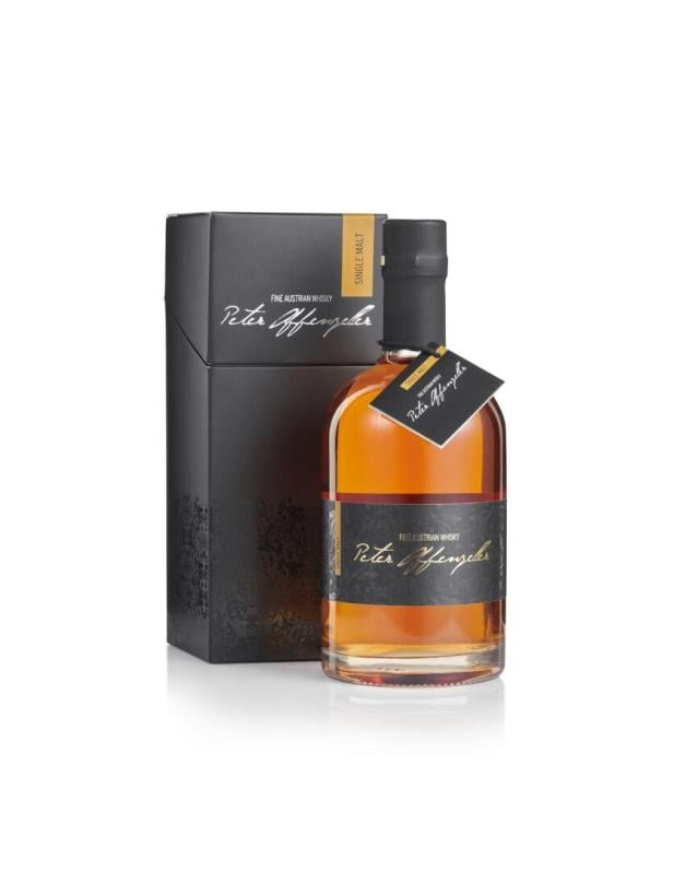 Eine Whiskyflasche mit schwarzem Etikett und passender Geschenkverpackung, beide mit goldener und weißer Schrift.