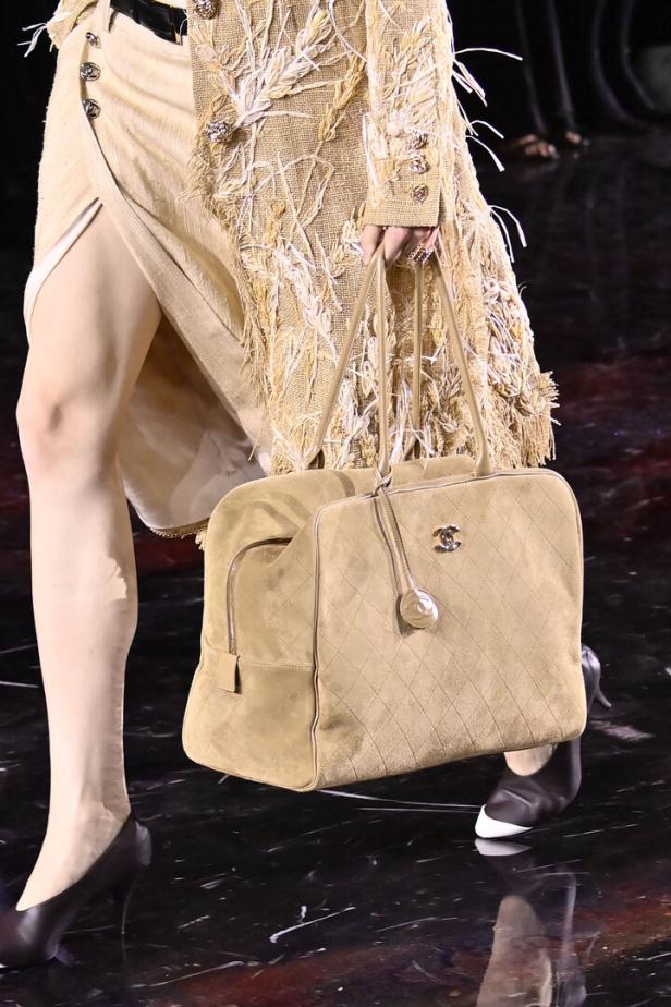 Eine Frau mit braunem Rock und brauner Tasche