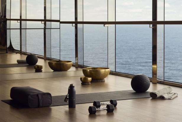 Ein Yogaraum mit Meerblick an Bord eines Kreuzfahrtschiffes mit Yogamatten und Yoga-Zubehör.