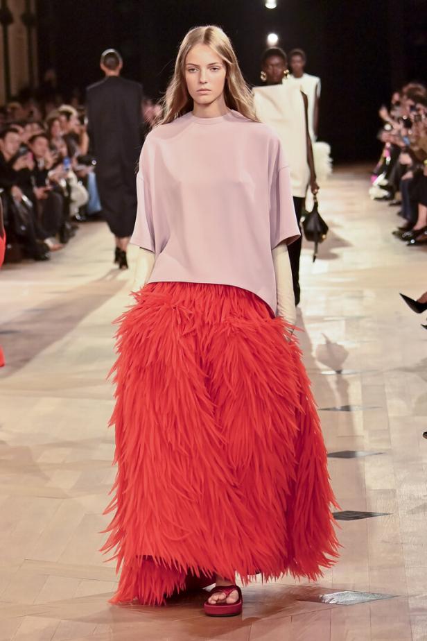 Lässig, gleichzeitig höchst elegant: Balenciaga-Abendlook mit rotem Federnrock, rosé Top, Handschuhen. Nur die Schlapfen wären am Opernball ein No-go.