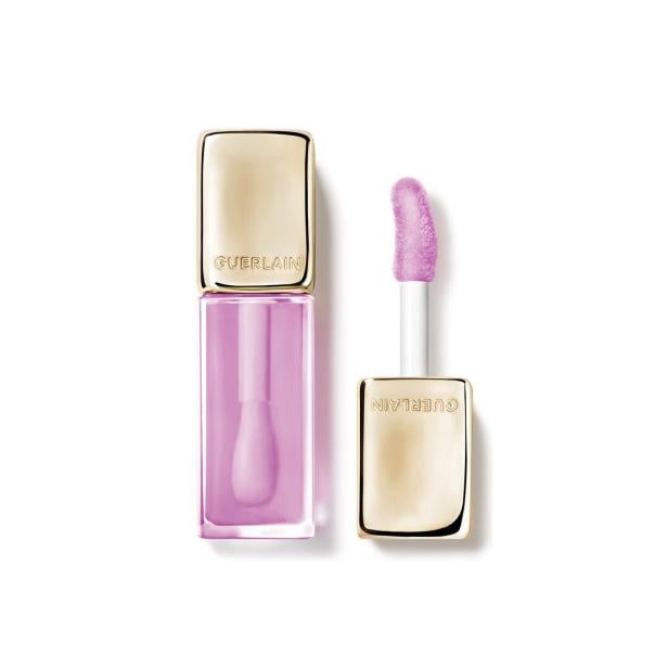 Ein geöffneter, rechteckiger Guerlain Lipgloss mit lila Inhalt und goldenem Deckel liegt auf weißem Grund.