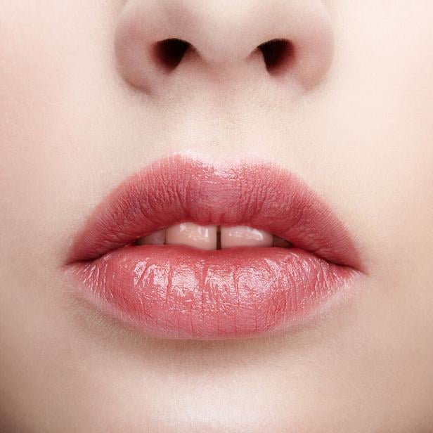 Nahaufnahme von glänzend geschminkten Lippen und einem Teil der Nase.