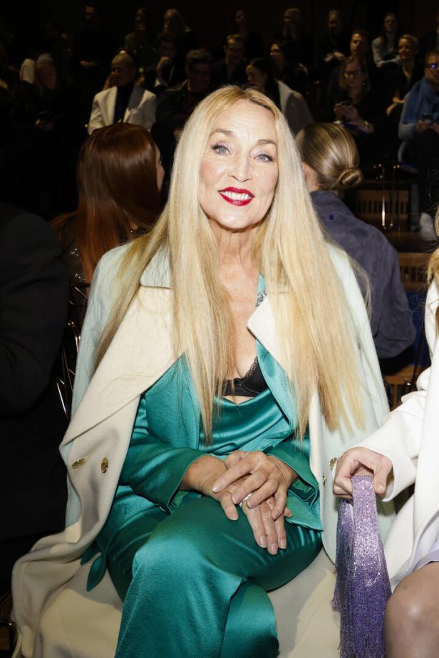 Jerry Hall in einem türkisen Kleid und langen, blonden Haaren bei der Marc Cain Fashion Show.