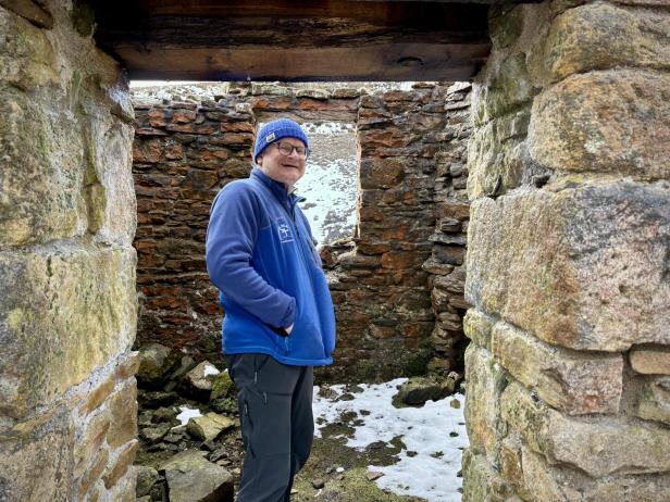 Mann in blauer Jacke in Ruine
