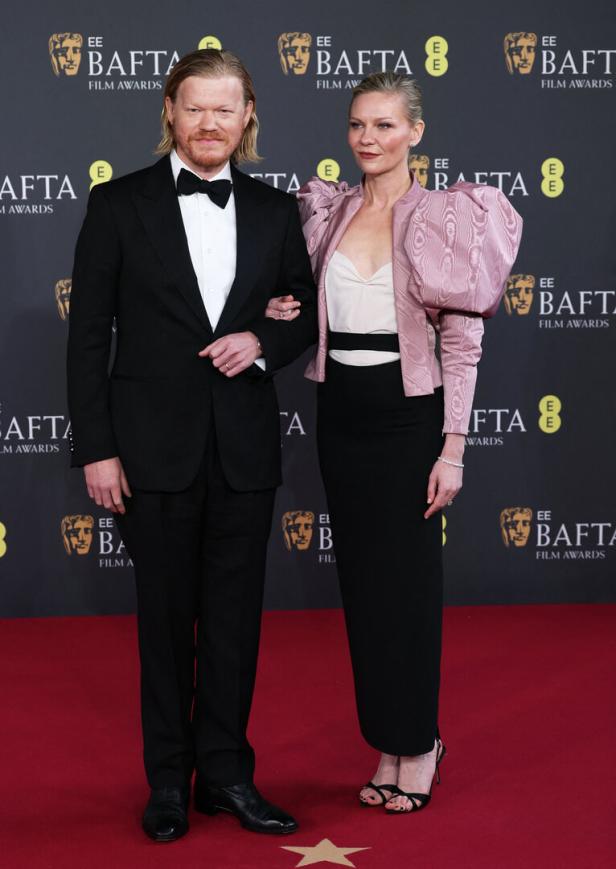Kirsten Dunst ehrte mit ihrem Zweiteiler und pompöser rosa Jacke den verstorbenen Modedesigner Valentino Garavani. An ihrer Seite: Ehemann Jesse Plemons.