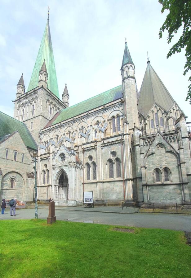 Die Fassade des Nidarosdoms in Trondheim mit grünem Dach und Turmspitze ist zu sehen.