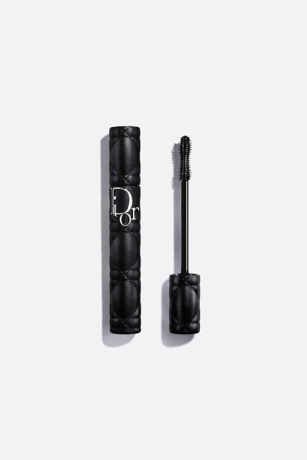 Eine schwarze Dior-Mascara mit Rautenmuster und Bürste liegt auf einem weißen Hintergrund.