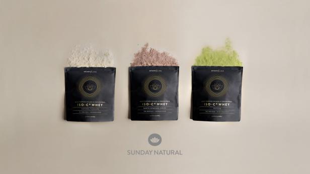 Packung des NuShape Metabolic Complete Mahlzeitenersatz-Shakes von Sunday Natural neben einem zubereiteten Shake.