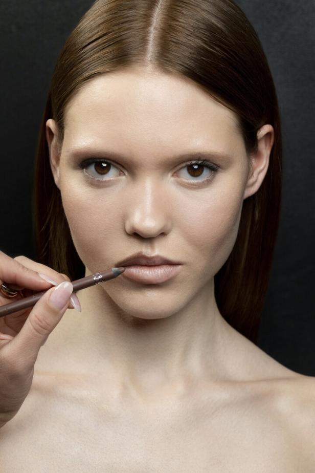 Mit einem weichen, leicht nougatfarbenen Konturenstift die Lippenkontur sanft überzeichnen und das Lippenherz betont weich ausmalen. 