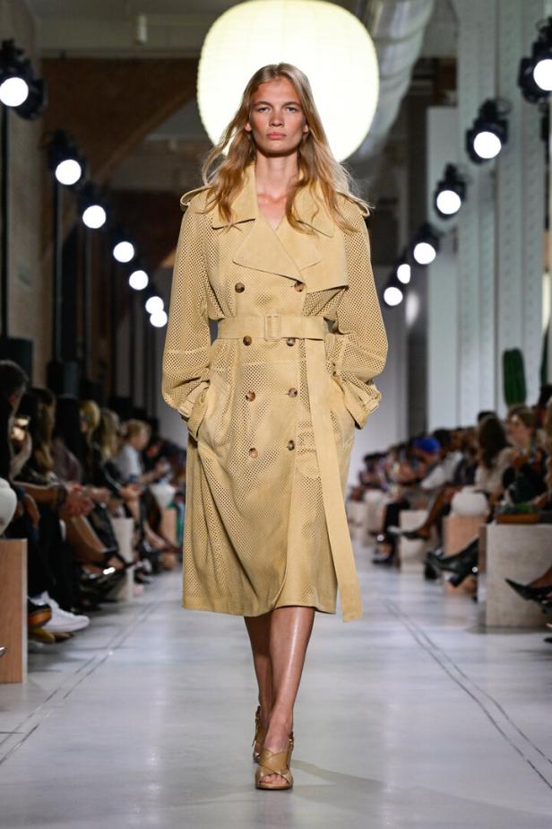 Eine Frau am Laufsteg in bananengelbem Trenchcoat 