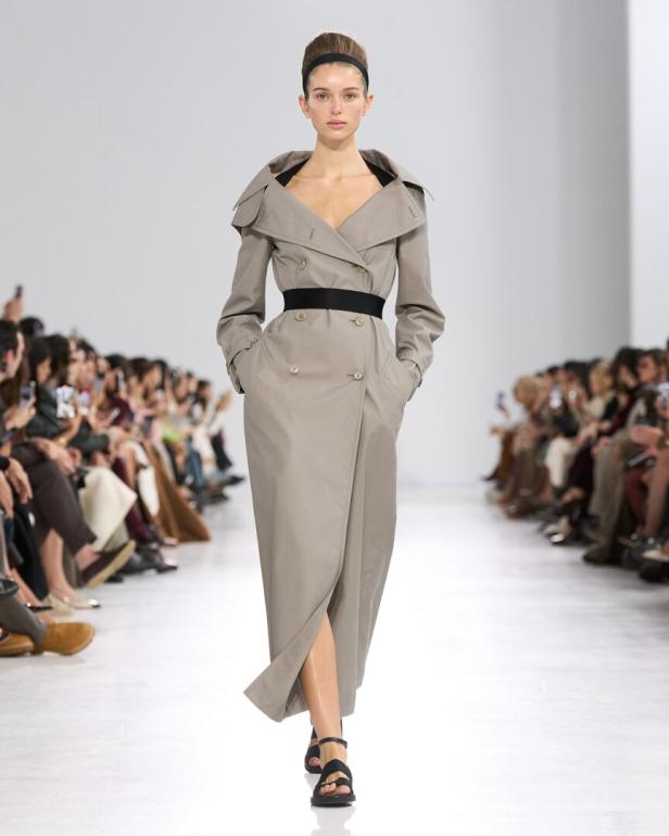 Frau am Laufsteg in grauem Trenchcoat