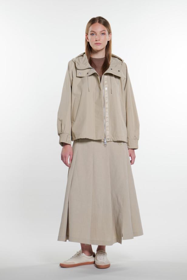 Frau in einer Blouson-Rock-Kombi in Trench-Optik in beige