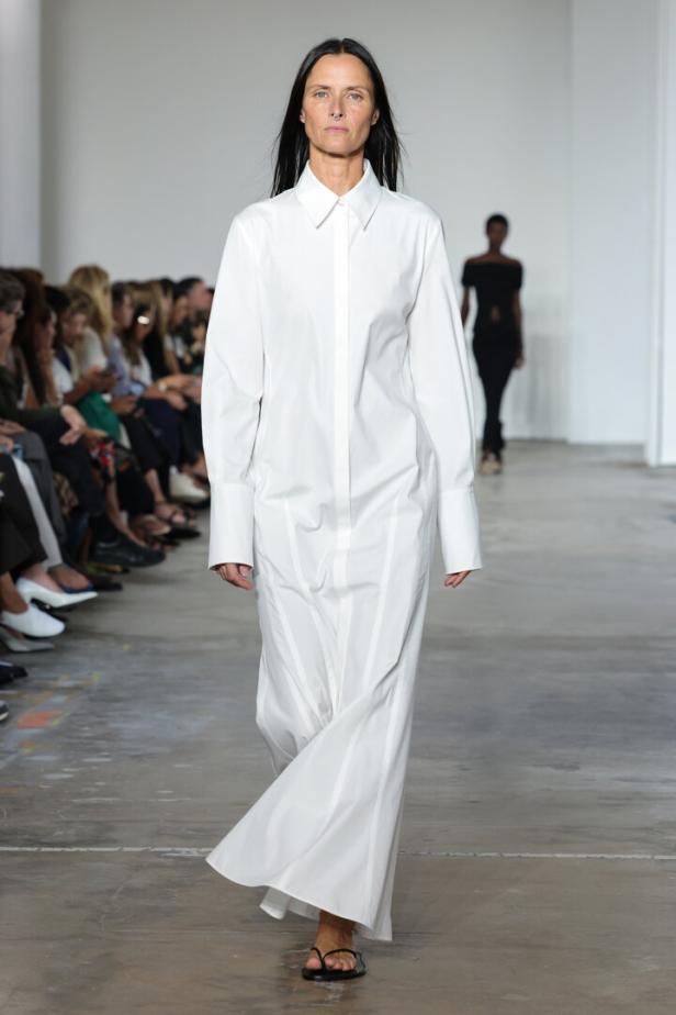 Frau am Laufsteg mit weißem bodenlangem Blusenkleid