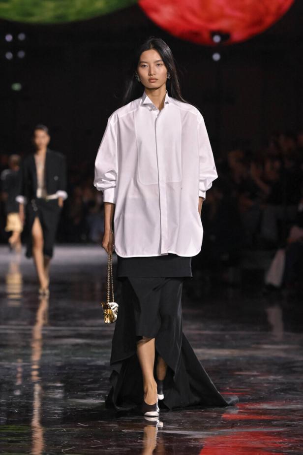 Frau am Runway in schwarzem Lagenrock und weißer Bluse