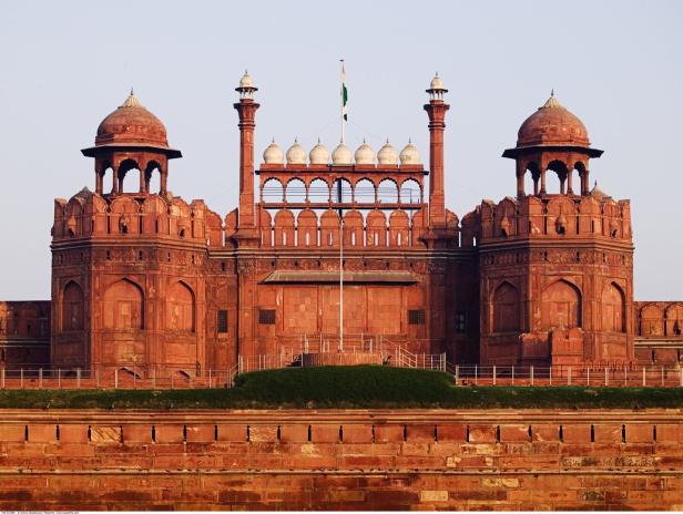 Rotes Sandstein-Fort mit zwei Türmen, zentralem Torbogen und indischer Flagge auf dem Dach.