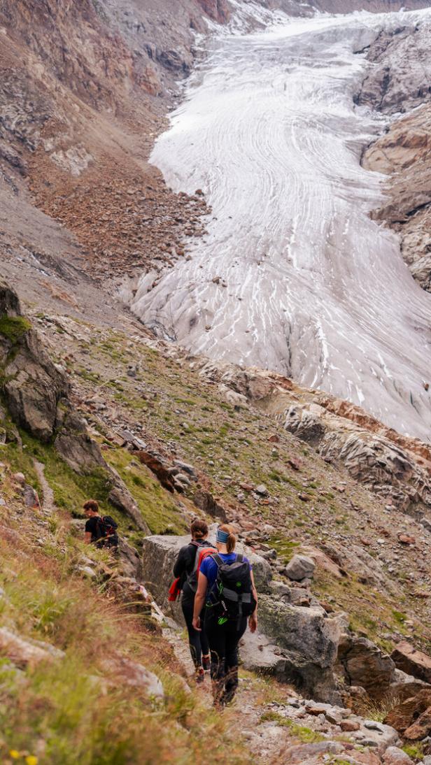Zwei Menschen auf dem Berg mit dem Gletscher voraus.