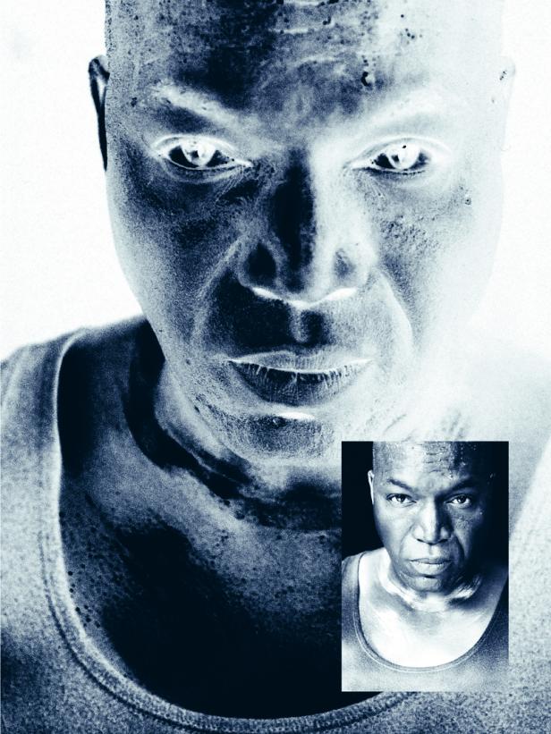 Ein Mann mit ernstem Blick, einmal in Negativfarben und einmal in normaler Darstellung, trägt ein ärmelloses Shirt.