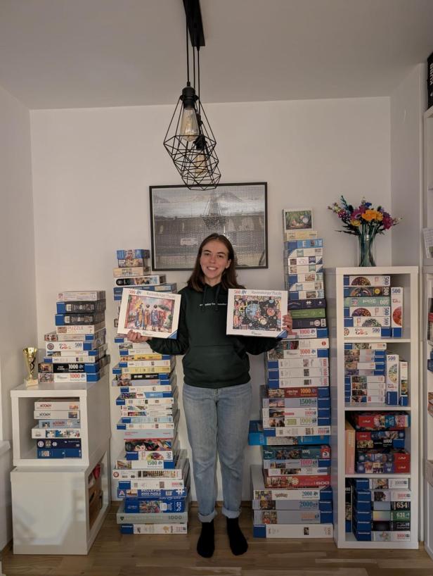 Simone Reicht steht zwischen ihren 200 Puzzles