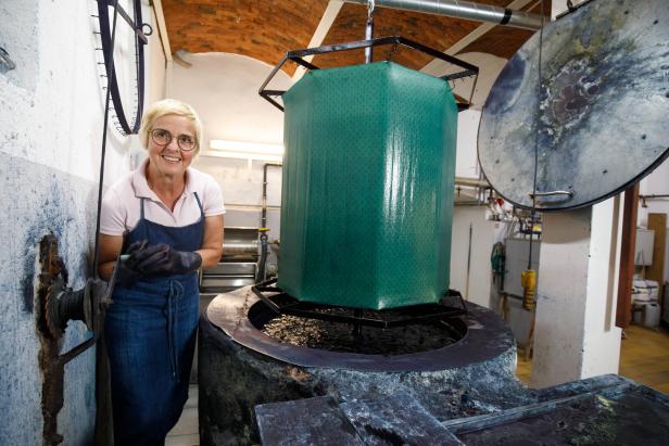 Maria Wagner neben der Indigo-Küpe: Kommt der Stoff aus der Farbe, wird er erst durch Oxidation an der Luft blau. 