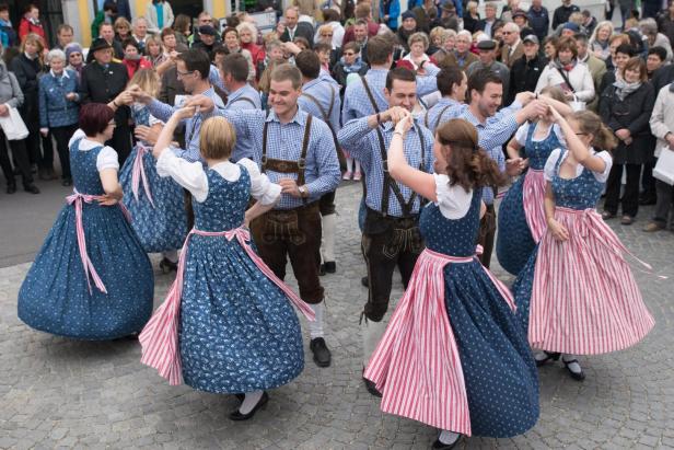 Paare in Blaudruck-Tracht tanzen 