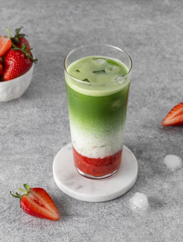 Matcha mit Erdbeerpüree, Milch und Eis in einem Glas