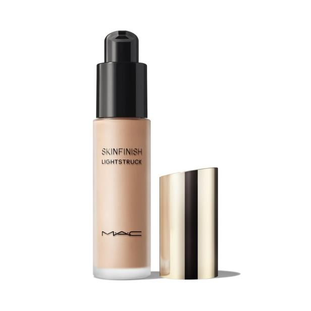 Eine Flasche MAC Skinfinish Lightstruck Foundation mit schwarzem Pumpspender und goldener Kappe steht auf weißem Grund.