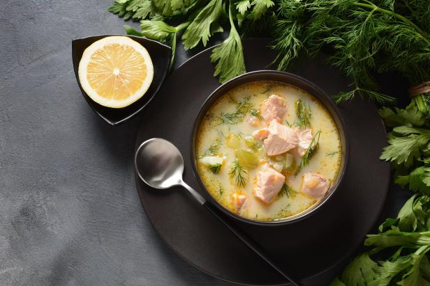 Lohikeitto: Finnische Lachssuppe mit Kartoffeln, angerichtet in einer schwarzen Schüssel mit Löffel und einer Zitronenscheibe.