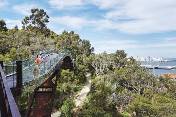 Ein Paar steht auf einer Brücke im Kings Park mit Blick auf Perth und den Swan River.