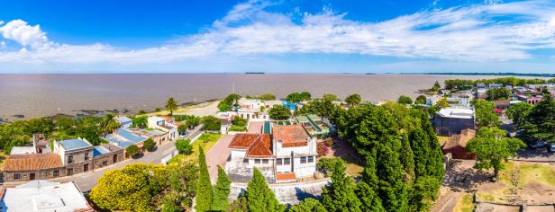 Panoramablick auf die historische Stadt Colonia del Sacramento in Uruguay mit Blick auf den Río de la Plata unter einem blauen Himmel.