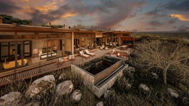 Modernes Haus mit großer Terrasse, Pool, Liegestühlen und Feuerstelle inmitten einer natürlichen Landschaft bei Sonnenuntergang.