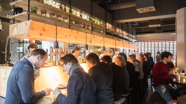 Gäste sitzen an einer Bar in einem Restaurant.