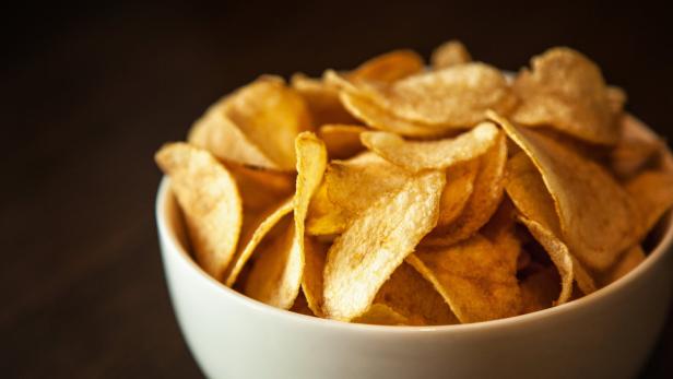 Eine Schüssel ist gefüllt mit goldgelben Kartoffelchips.