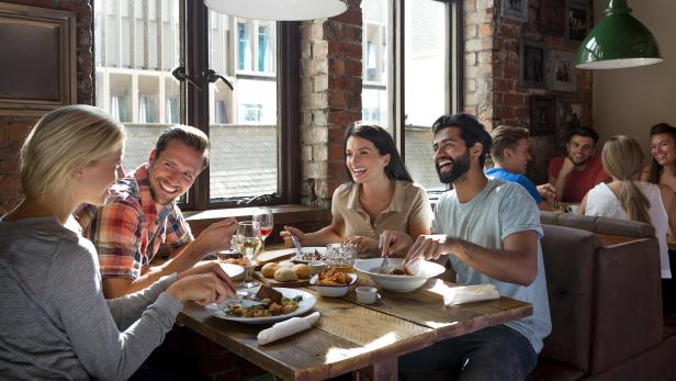 Eine Gruppe von Freunden genießt gemeinsam eine Mahlzeit in einem Restaurant.