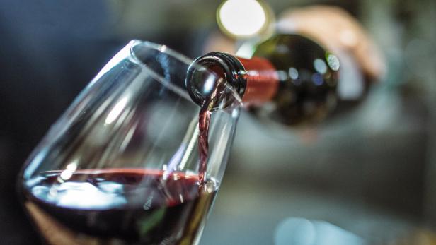 Ein Glas Rotwein wird eingeschenkt.