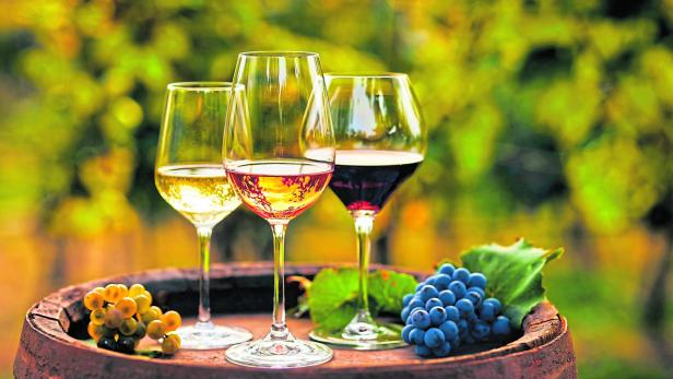 Three glasses of white, ros?É¬© and red wine and an old wooden barrel, with winery still life