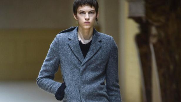 Ein sehr dünner Mann im Mantel bei der Prada Show