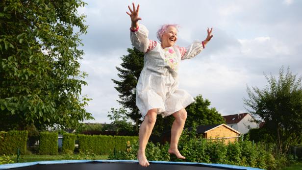 Senior woman with overweight jumping on trampoline