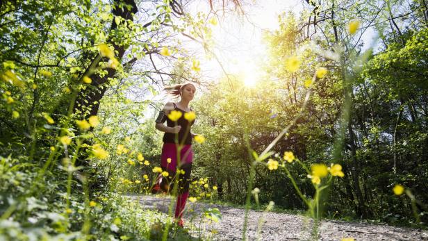 Young sporty woman jogging through the forest.