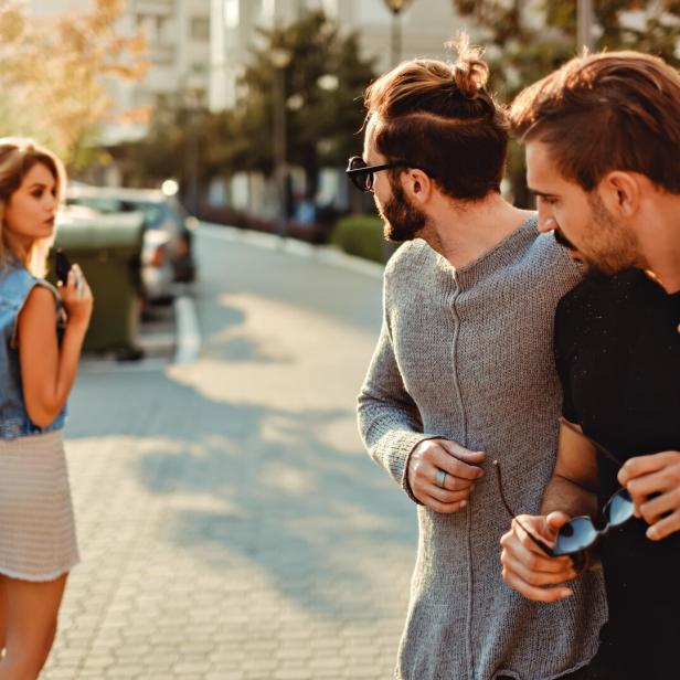 Male friends looking at the girl in the street