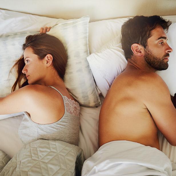 Ein Paar liegt im Bett und verzichtet auf Geschlechtsverkehr