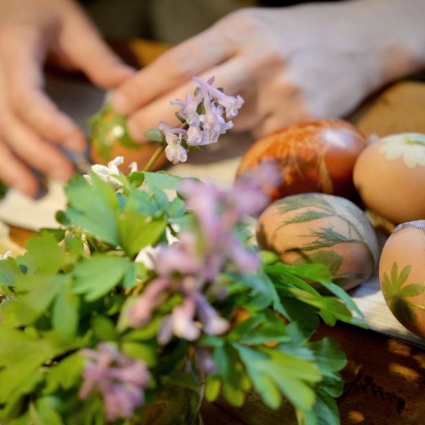 Bunte Ostereier mit Pflanzenmotiven werden verziert.