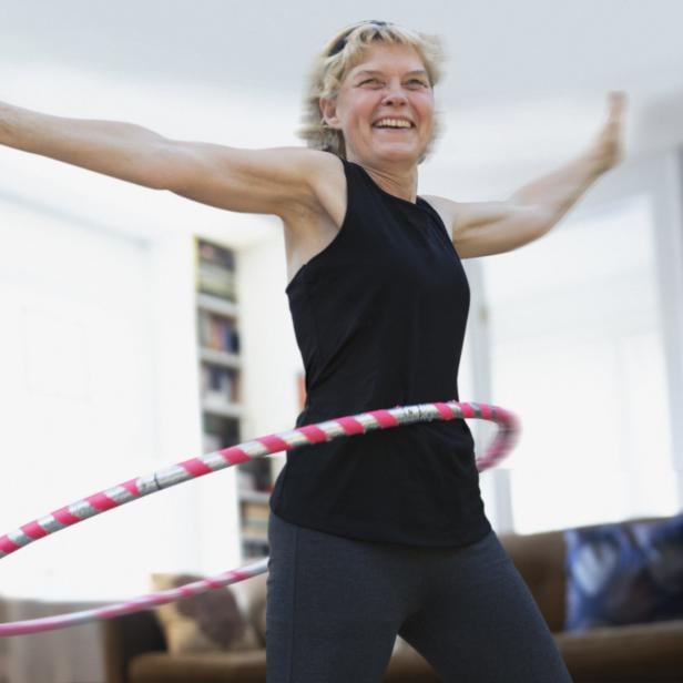 Frau hat Spaß an Bewegung mit Hula Hoop-Reifen