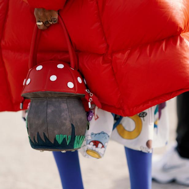 Modriger Streetstyle: Eine Frau in Paris trägt Fliegenpilz-Tasche
