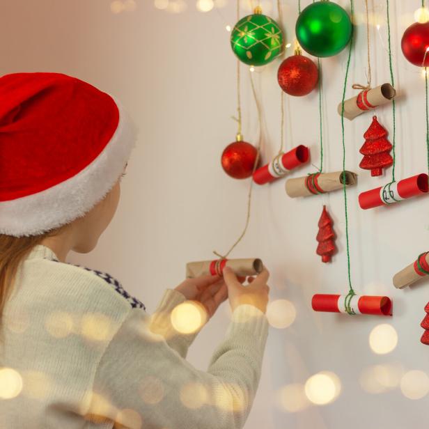 Ein Mädchen öffnet ein Kästchen bei einem Adventkalender.